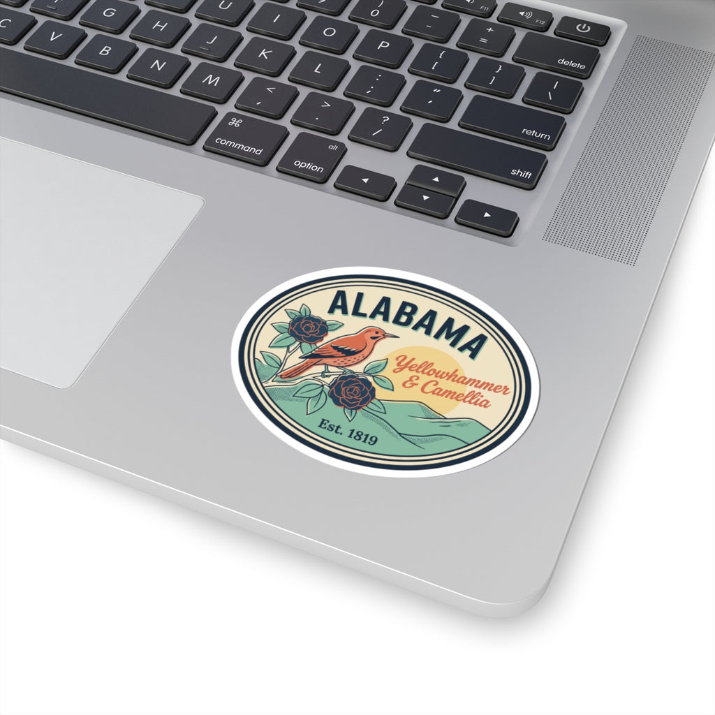 Alabama oval vinyl sticker on silver laptop lid, bird-and-rose state badge design