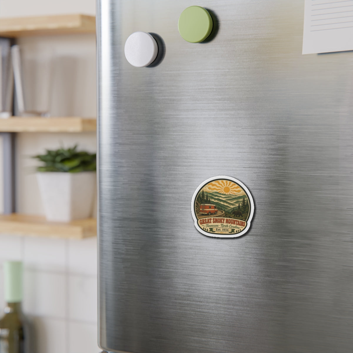 Small round die-cut magnet on stainless fridge showing Great Smoky Mountains van scene