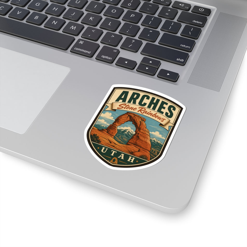 Shield-shaped Arches Utah kiss-cut sticker with Delicate Arch and Stone Rainbows banner, angled