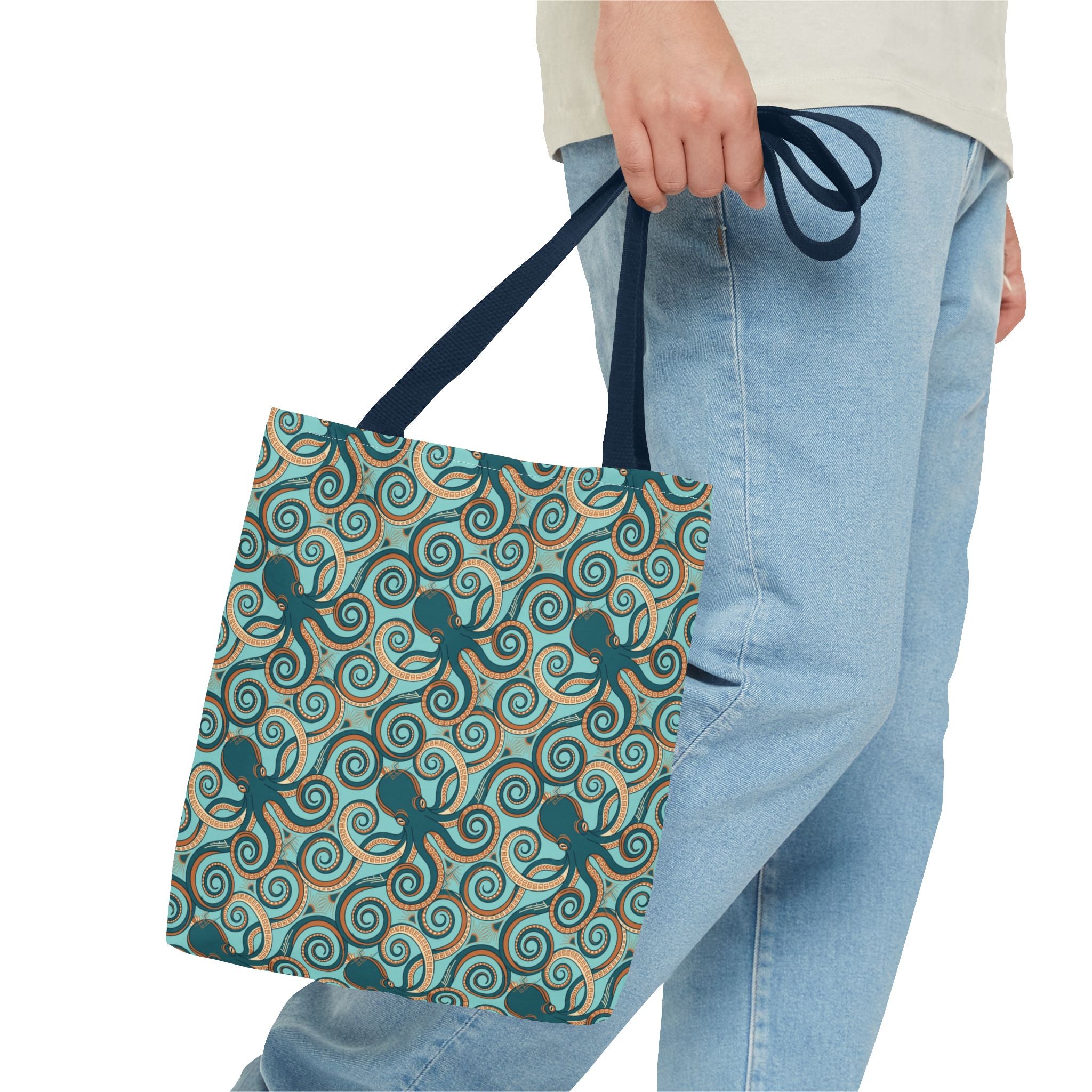 Teal octopus swirl tote bag with navy handles, shown in hand-carry view.