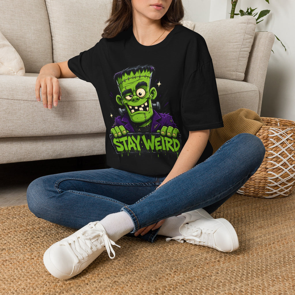 Black T-shirt worn by model with green Frankenstein graphic and “Stay Weird”