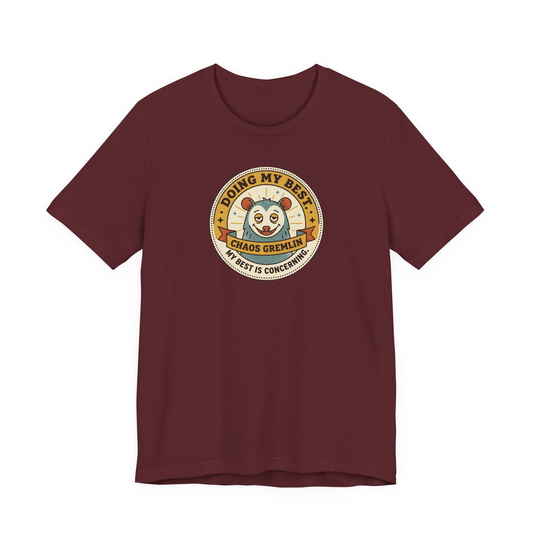 Maroon T-shirt with round cartoon gremlin badge graphic on the chest