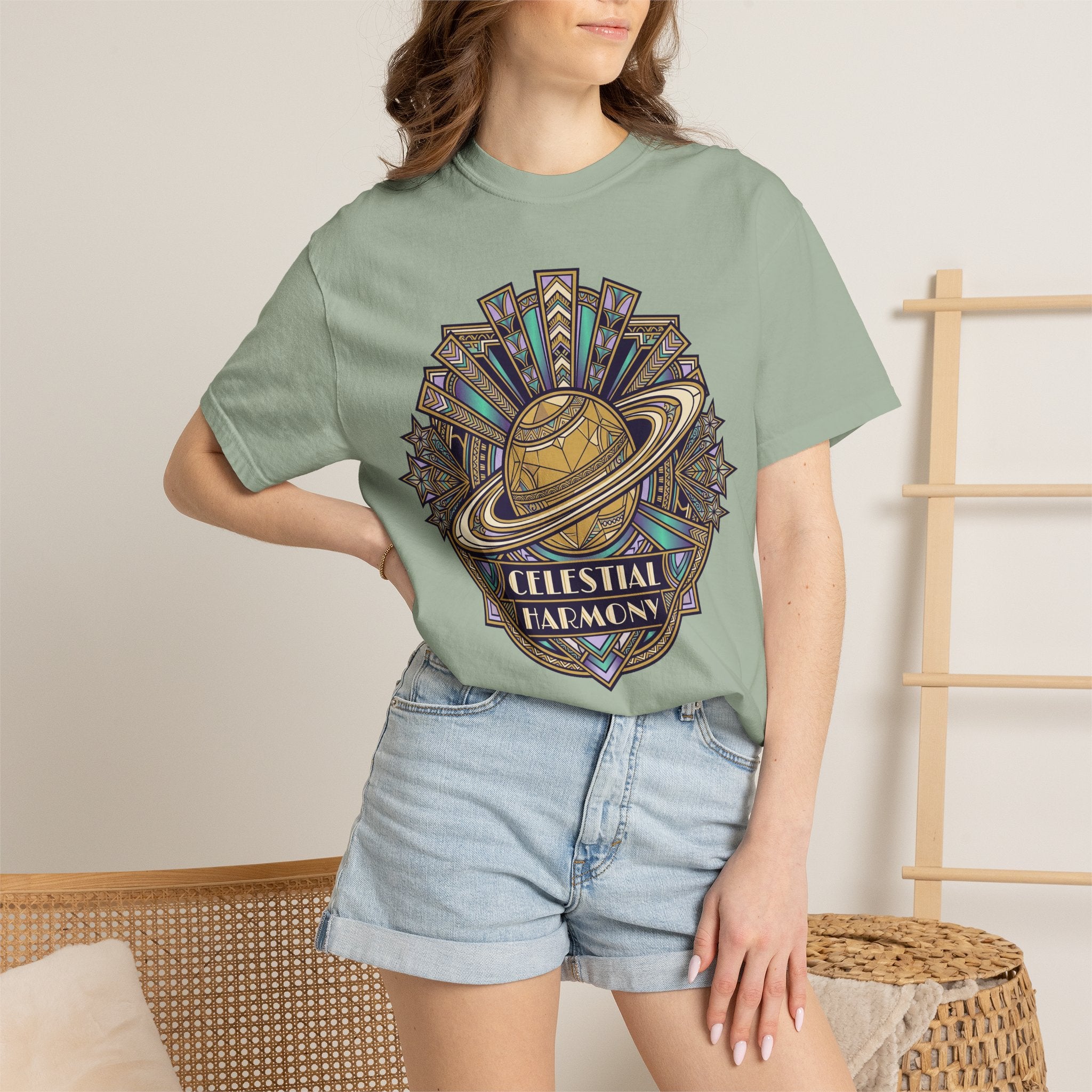 Celestial graphic T-shirt in sage green with “CELESTIAL HARMONY” text.