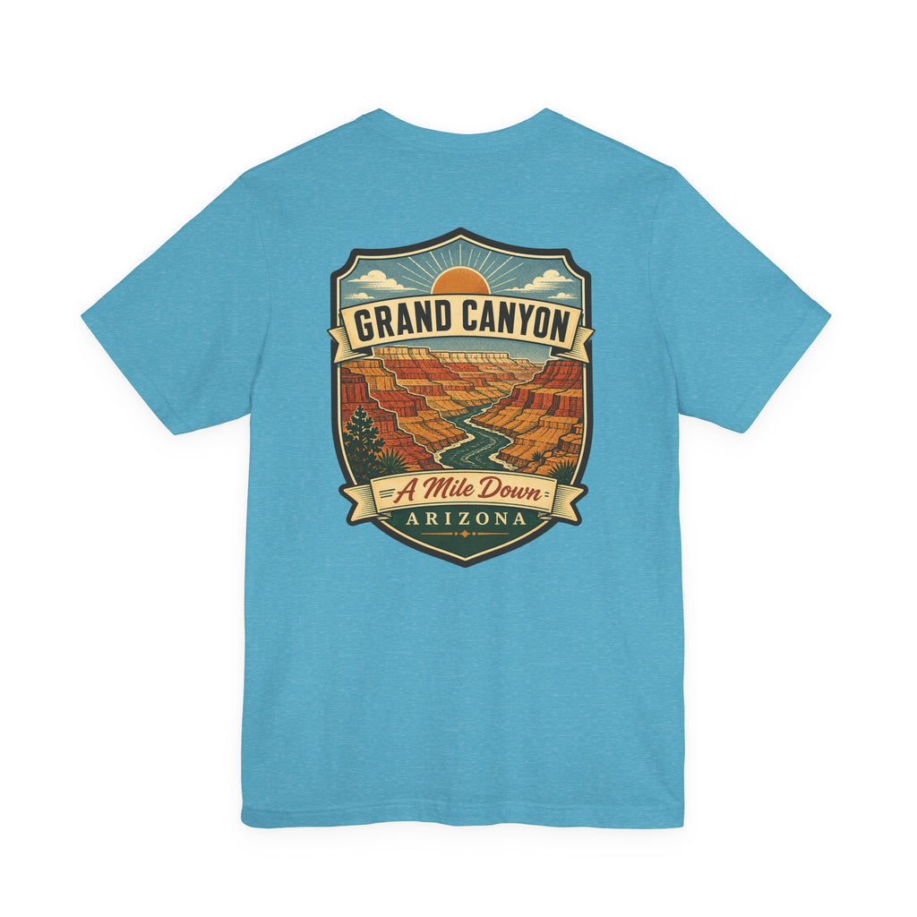 Light blue crew-neck t-shirt with large Grand Canyon scenic graphic and banner text.