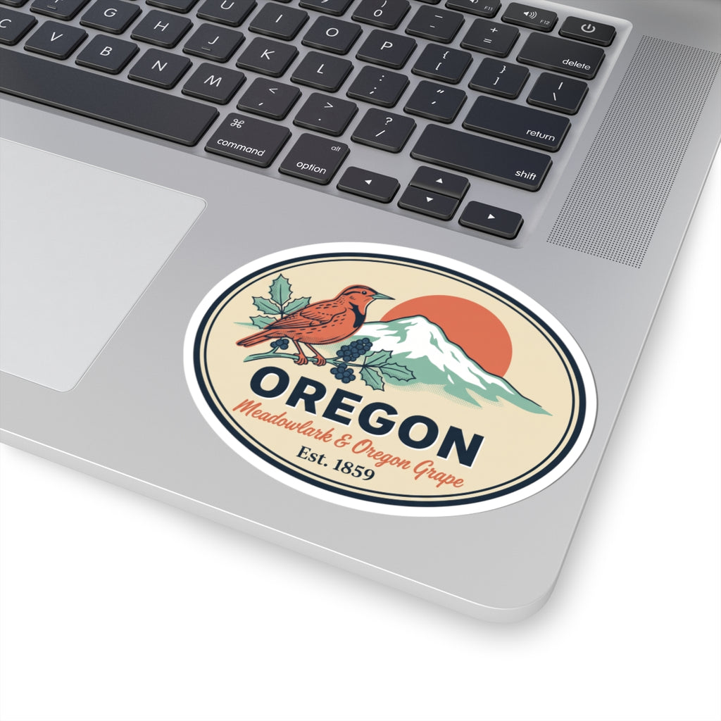 Oval Oregon label sticker on laptop lid showing meadowlark, grape vine, mountains, Est. 1859.