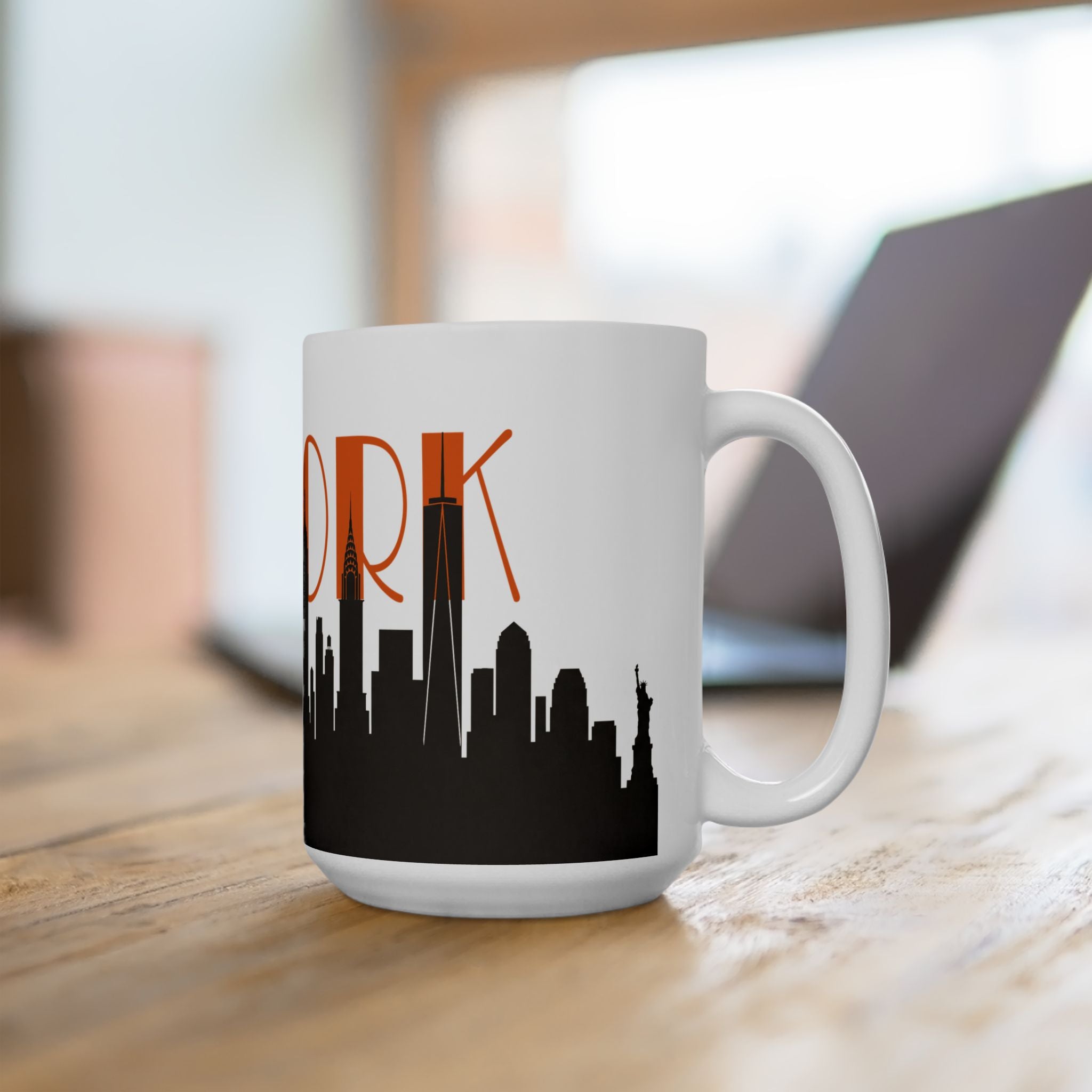 White ceramic coffee mug with orange “ORK” text and black city skyline