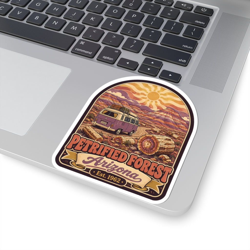 Kiss-cut desert camper van sticker on laptop lid, purple van, sun, logs, 'Petrified Forest Arizona Est. 1962'.