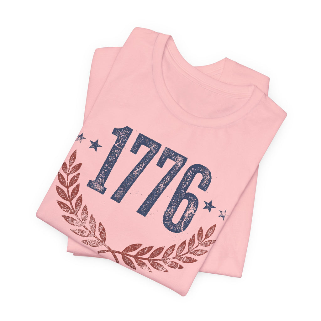 Pink t-shirt with 1776 laurel wreath graphic, folded front view