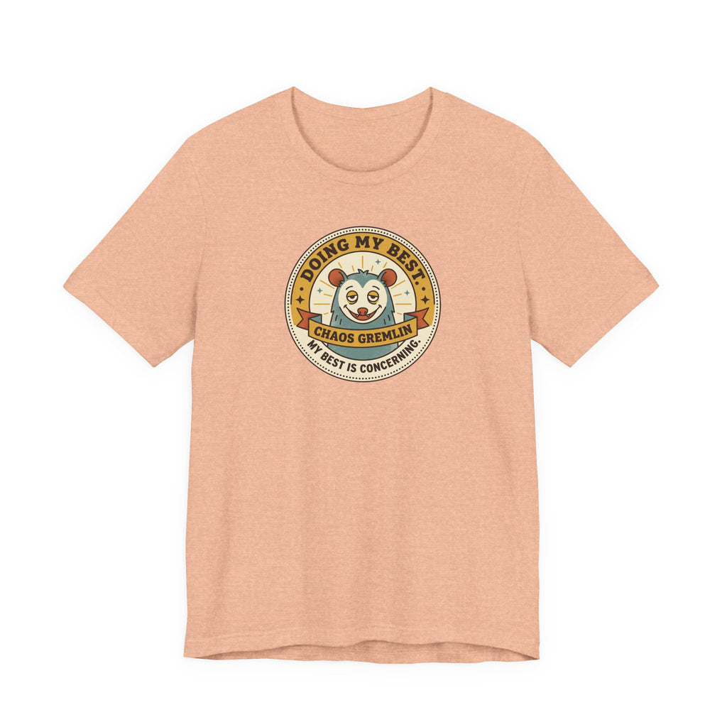Peach T-shirt with round gremlin badge graphic on center chest