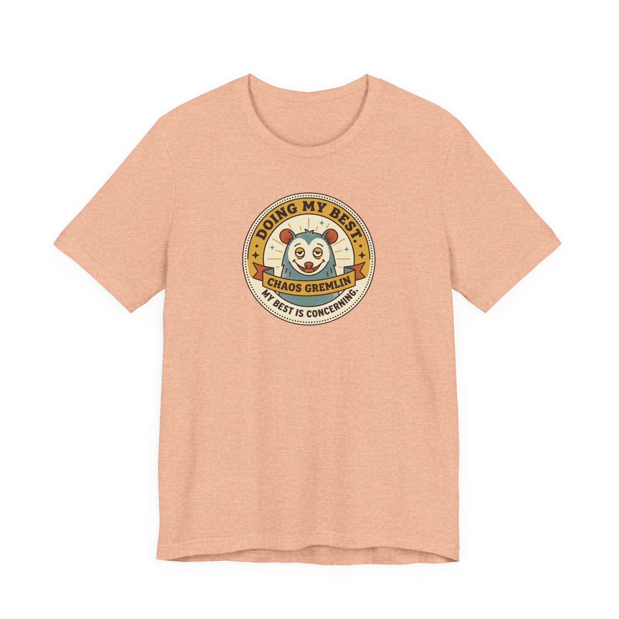 Peach T-shirt with round gremlin badge graphic on center chest
