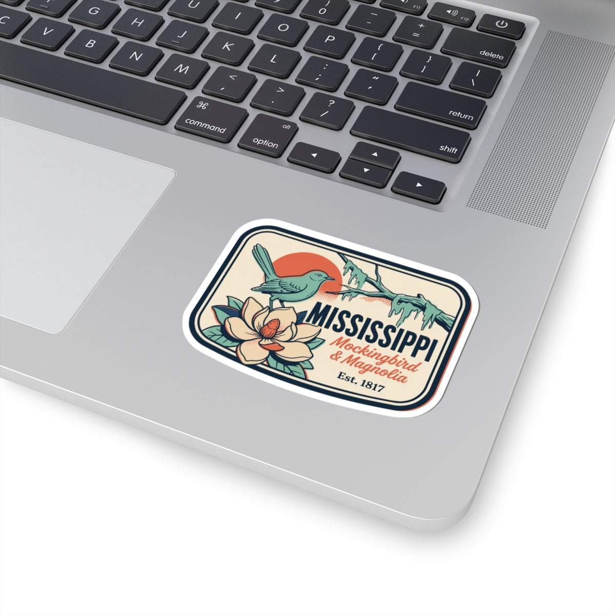 Mississippi state vinyl sticker on a laptop trackpad area, mockingbird and magnolia graphic