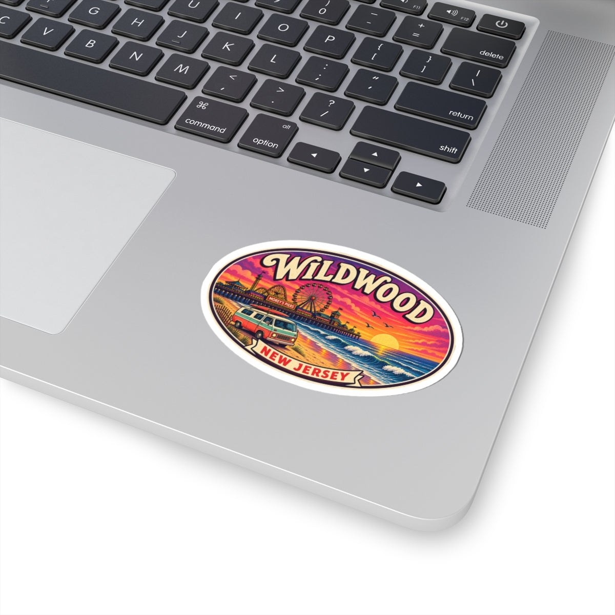 Oval sticker with Wildwood brand text and illustrated beach, waves, and sunset.