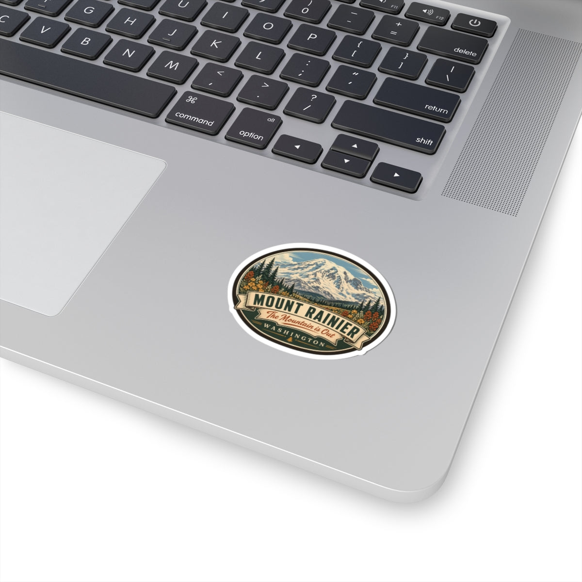 Round travel sticker with illustrated mountain badge and Mount Rainier lettering