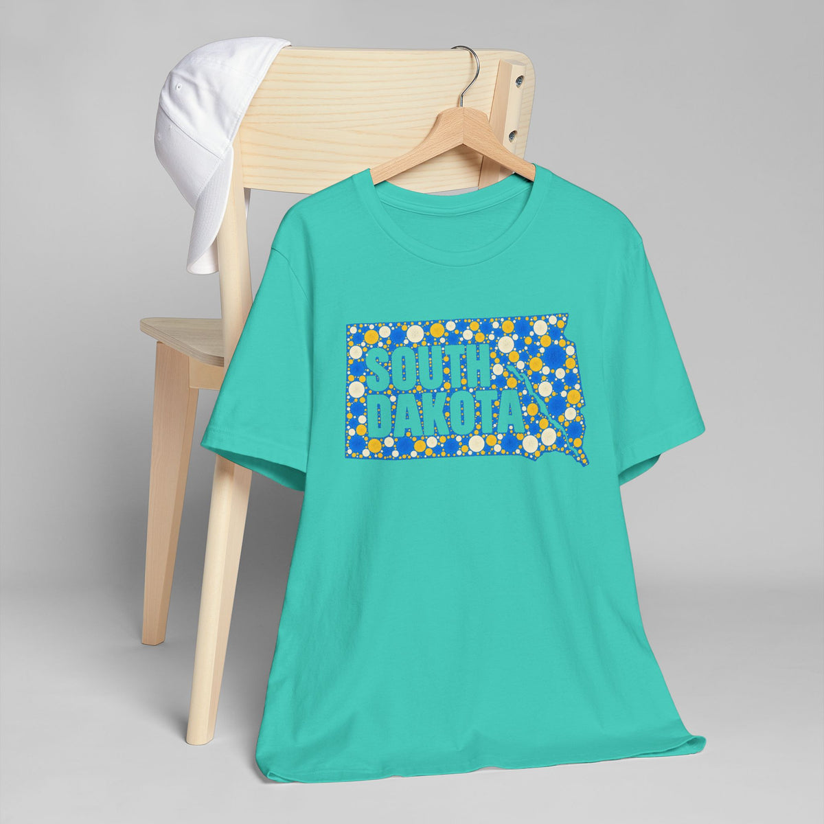 Teal crewneck t-shirt with blue polka-dot South Dakota graphic on chest.