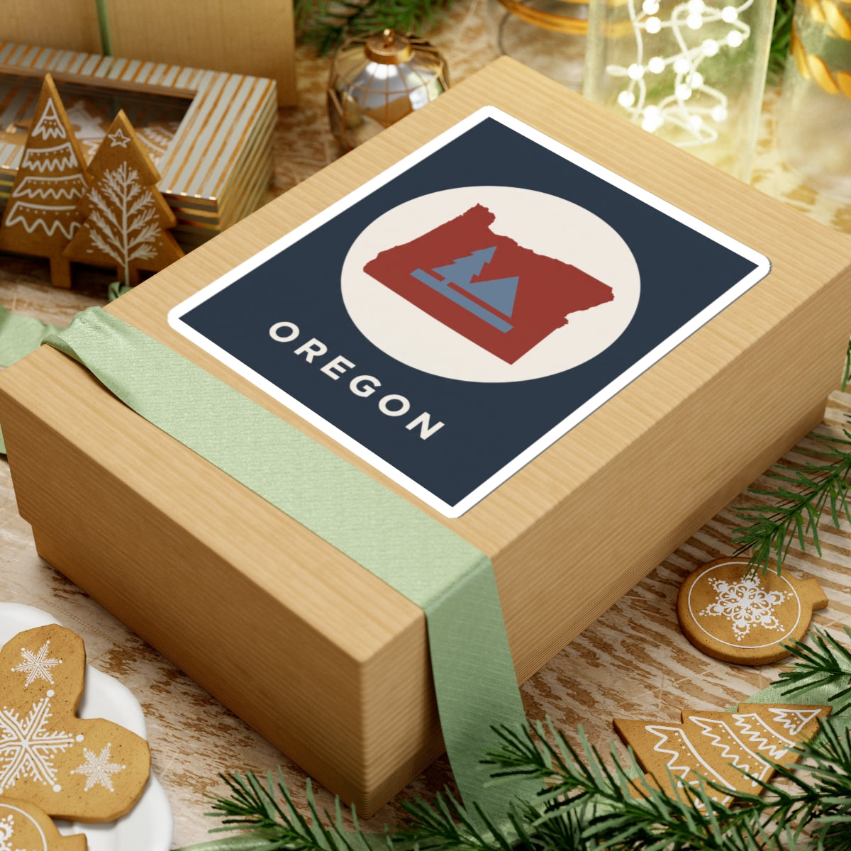 Square sticker featuring Oregon silhouette in red with pine tree and mountain graphic; OREGON.