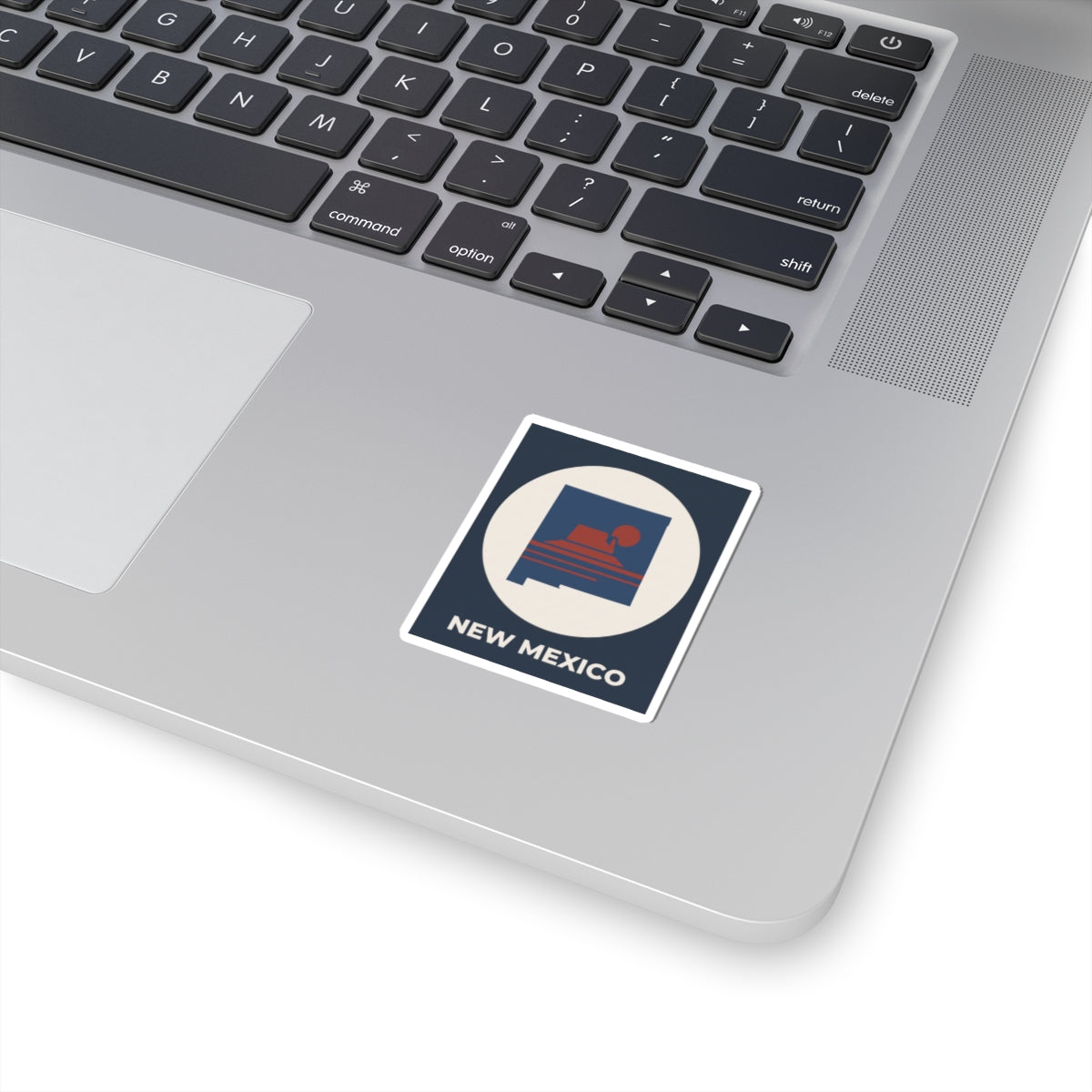 Kiss-cut square sticker with New Mexico outline and sunset graphic on laptop
