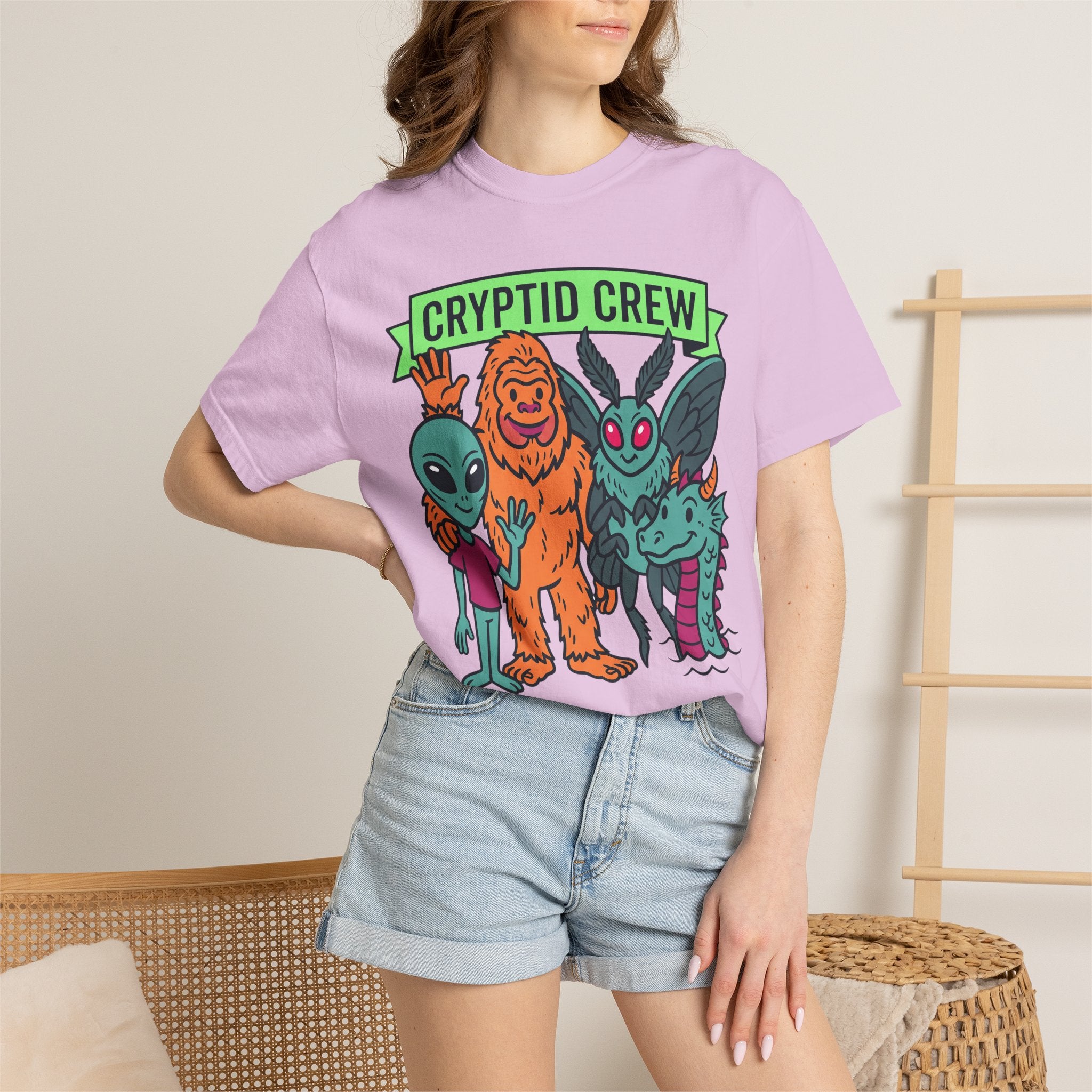 Lavender crew neck t-shirt with multicolor cryptid graphic and green 'CRYPTID CREW' text