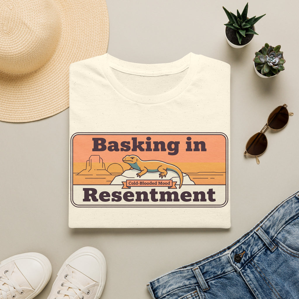White lizard graphic T-shirt with retro desert print: “Basking in Resentment”.