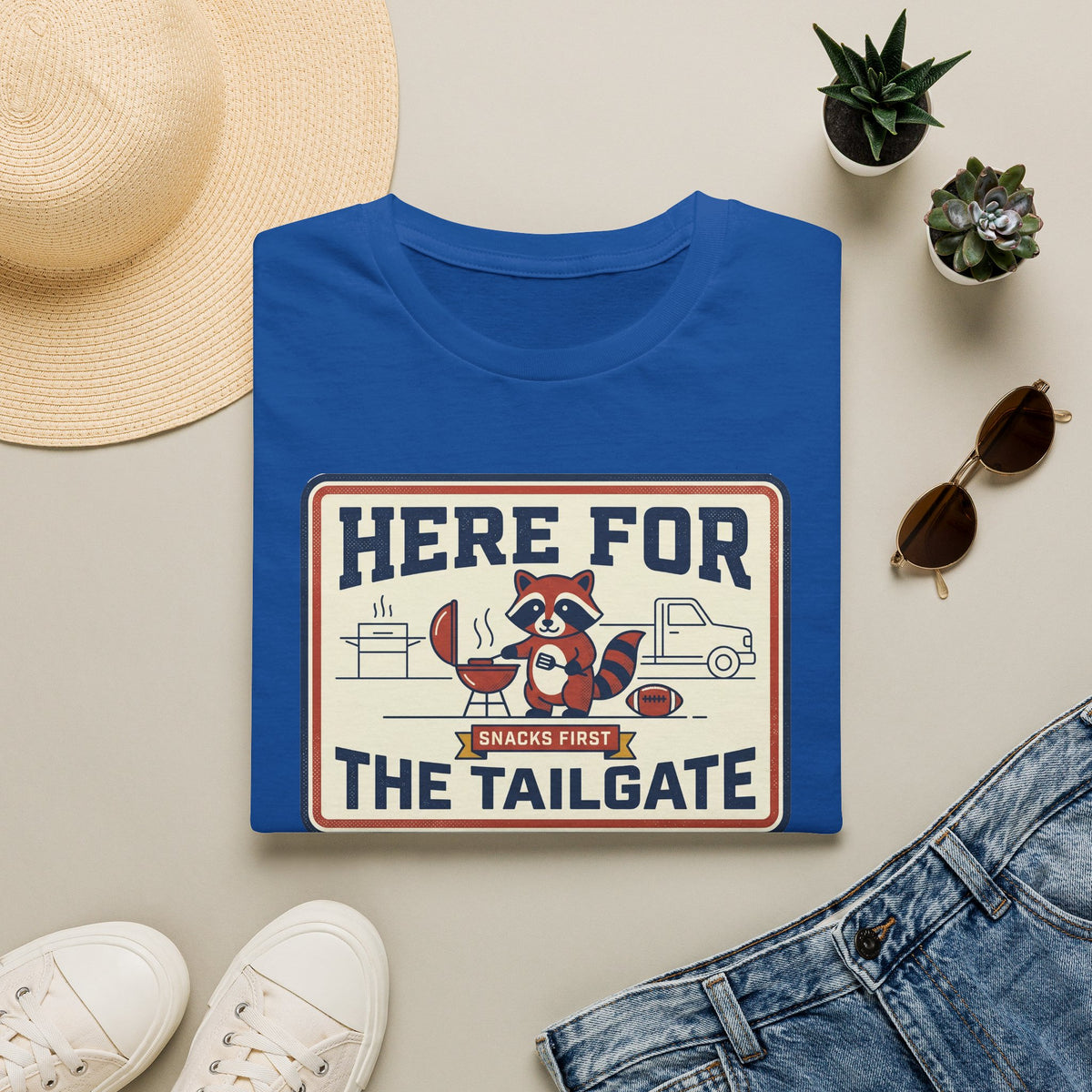 Royal blue crewneck T-shirt with “Here for the Tailgate” raccoon graphic