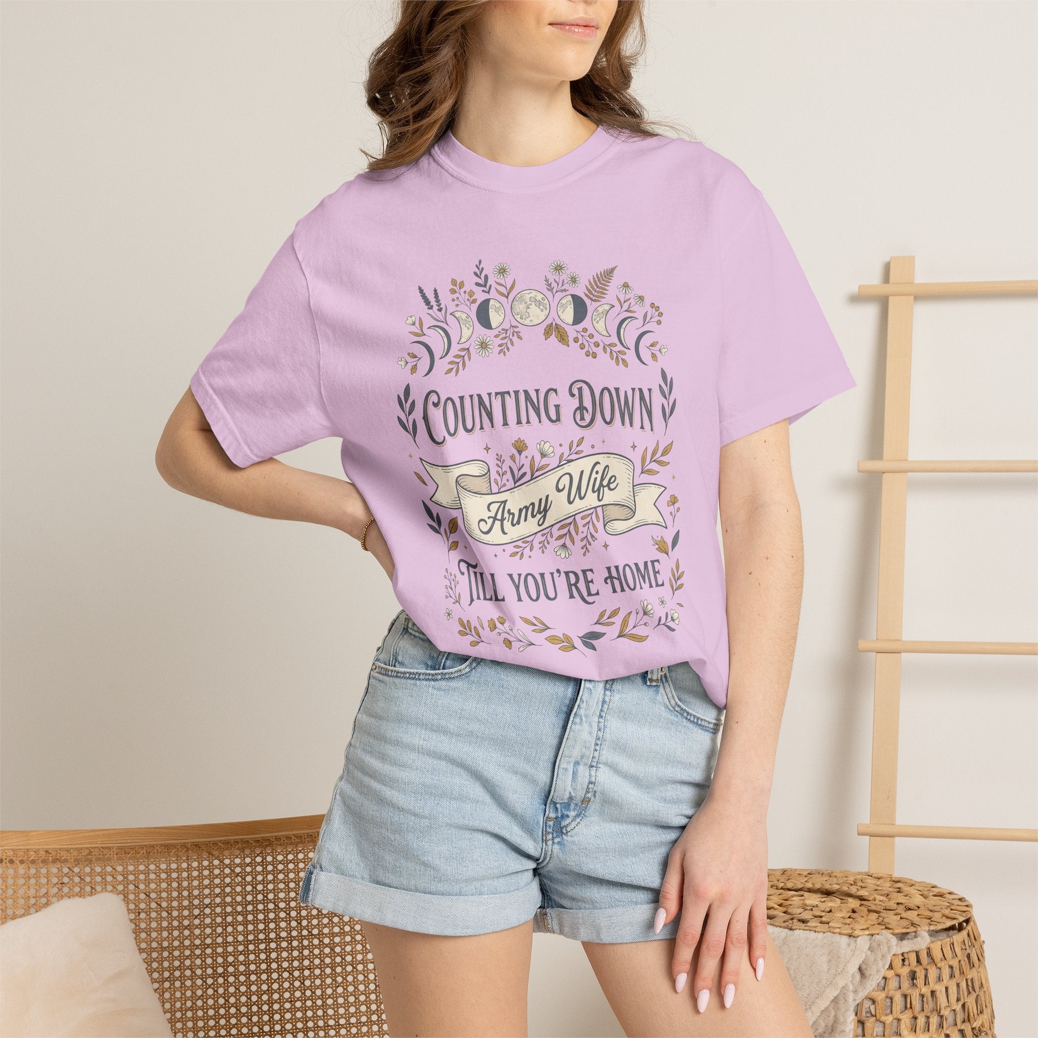 Model wearing a light pink army wife countdown T-shirt with floral “Counting Down” graphic