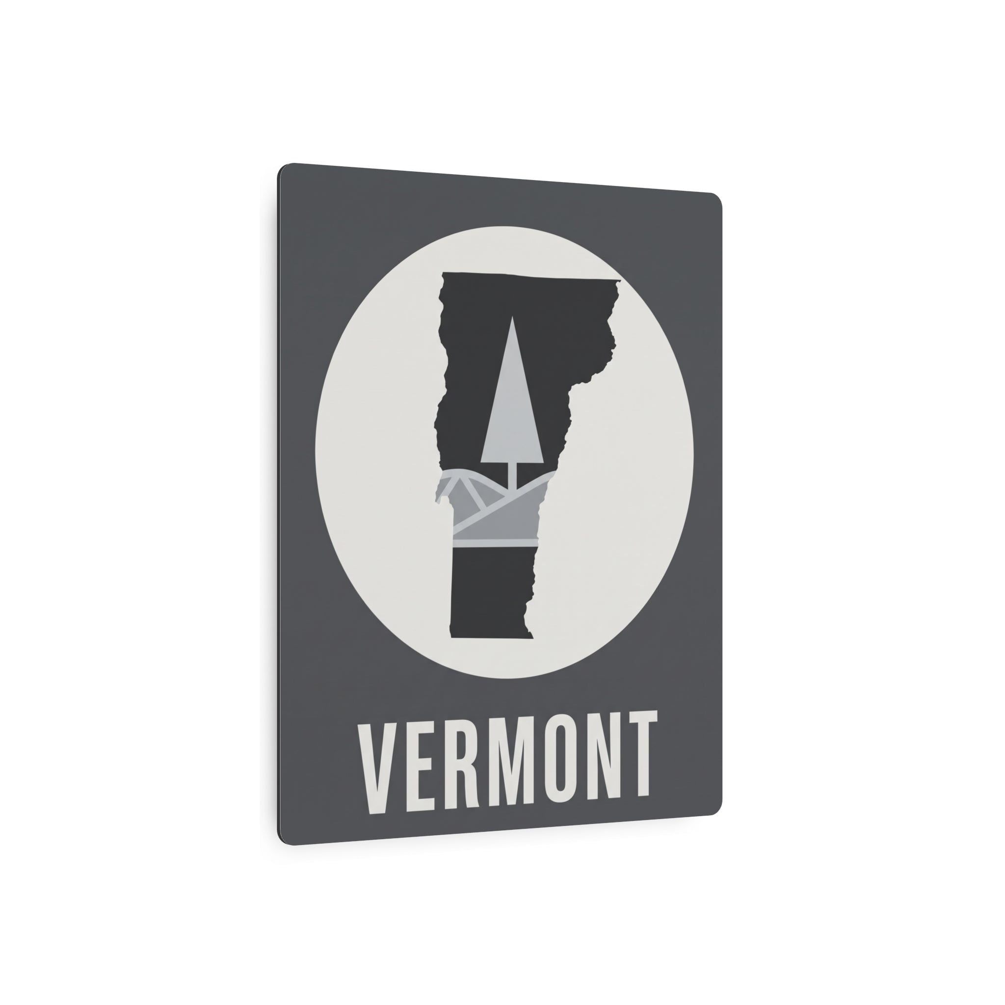 Front of Vermont metal wall sign: circular pine-tree silhouette on dark gray, “VERMONT”.