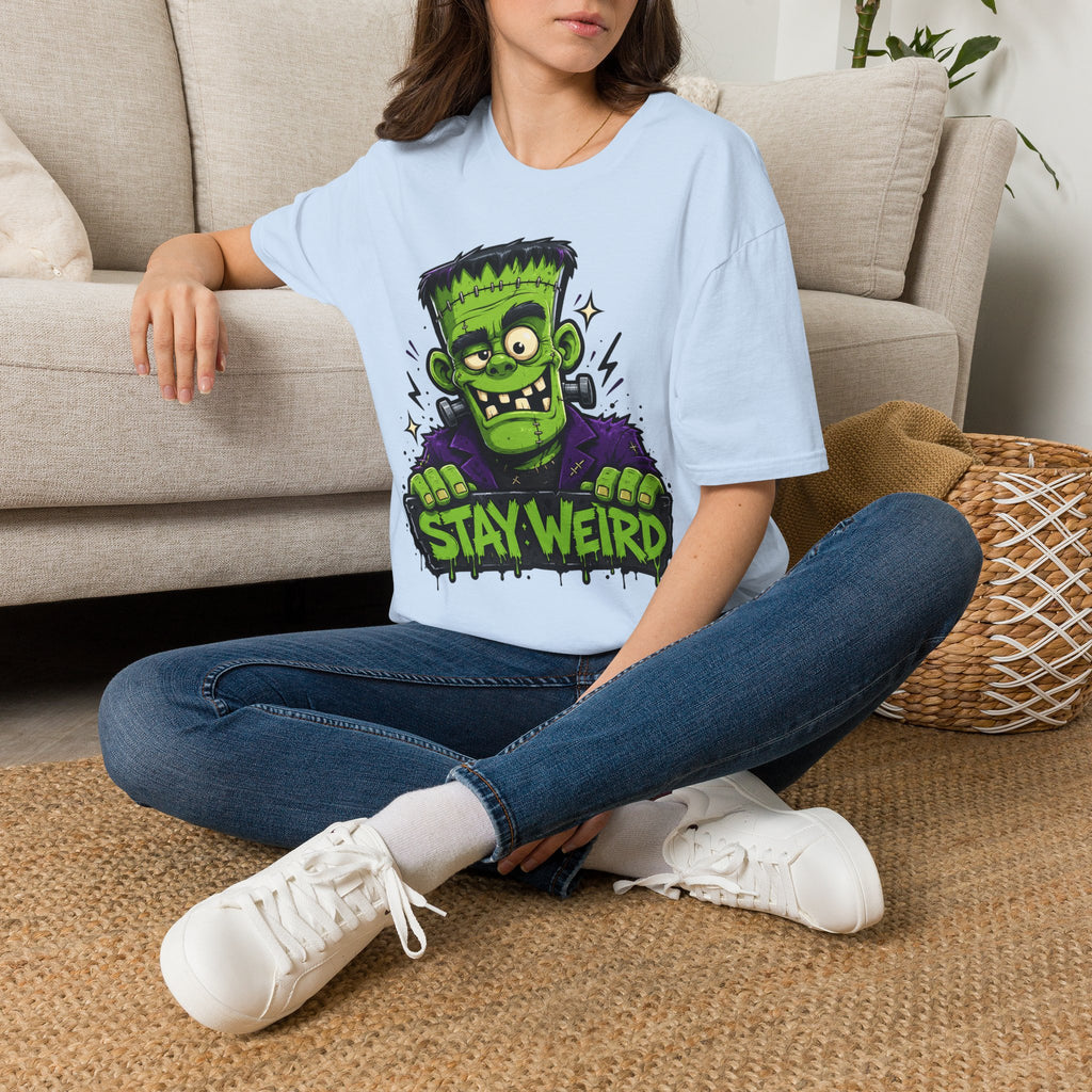 Light blue crewneck T-shirt with green cartoon monster “STAY WEIRD” graphic
