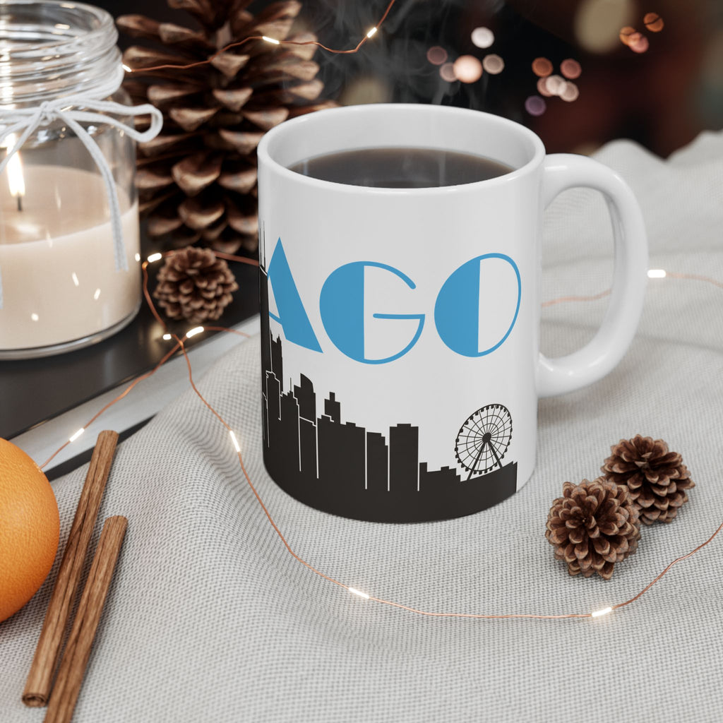 White ceramic mug with dark drink, black skyline base, blue 'AGO' and ferris wheel