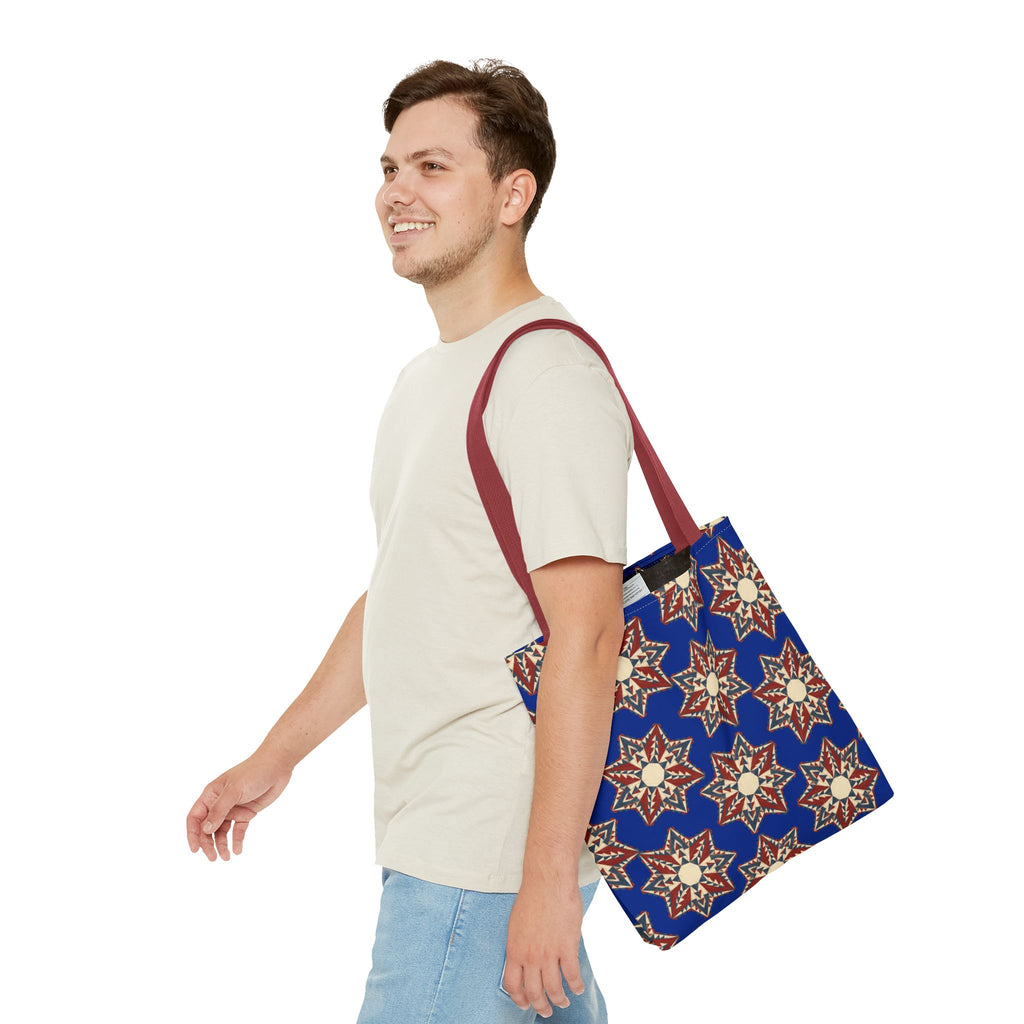 Blue tote bag with starburst floral print and red shoulder straps