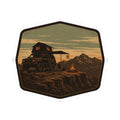 Overlander campfire sticker, octagon border with desert ground, truck, and mountain silhouettes