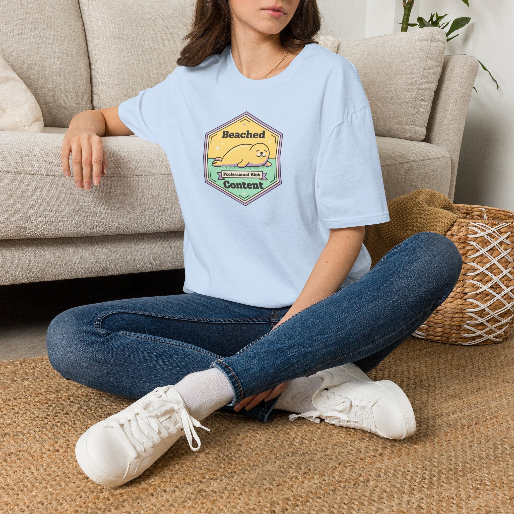 Light blue T-shirt with chest Beached Content seal badge graphic and short sleeves