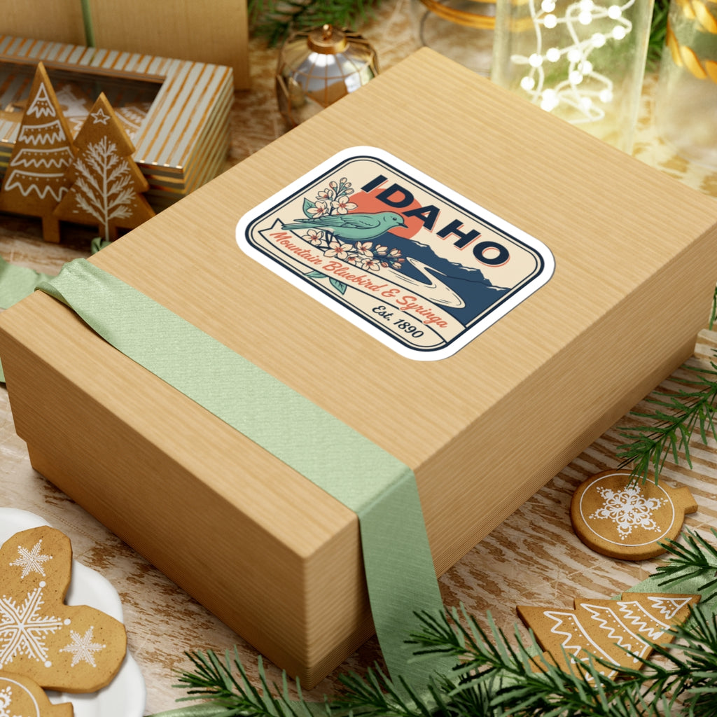 Idaho badge vinyl sticker on gift box, featuring Mountain Bluebird & Syringa and Est. 1890