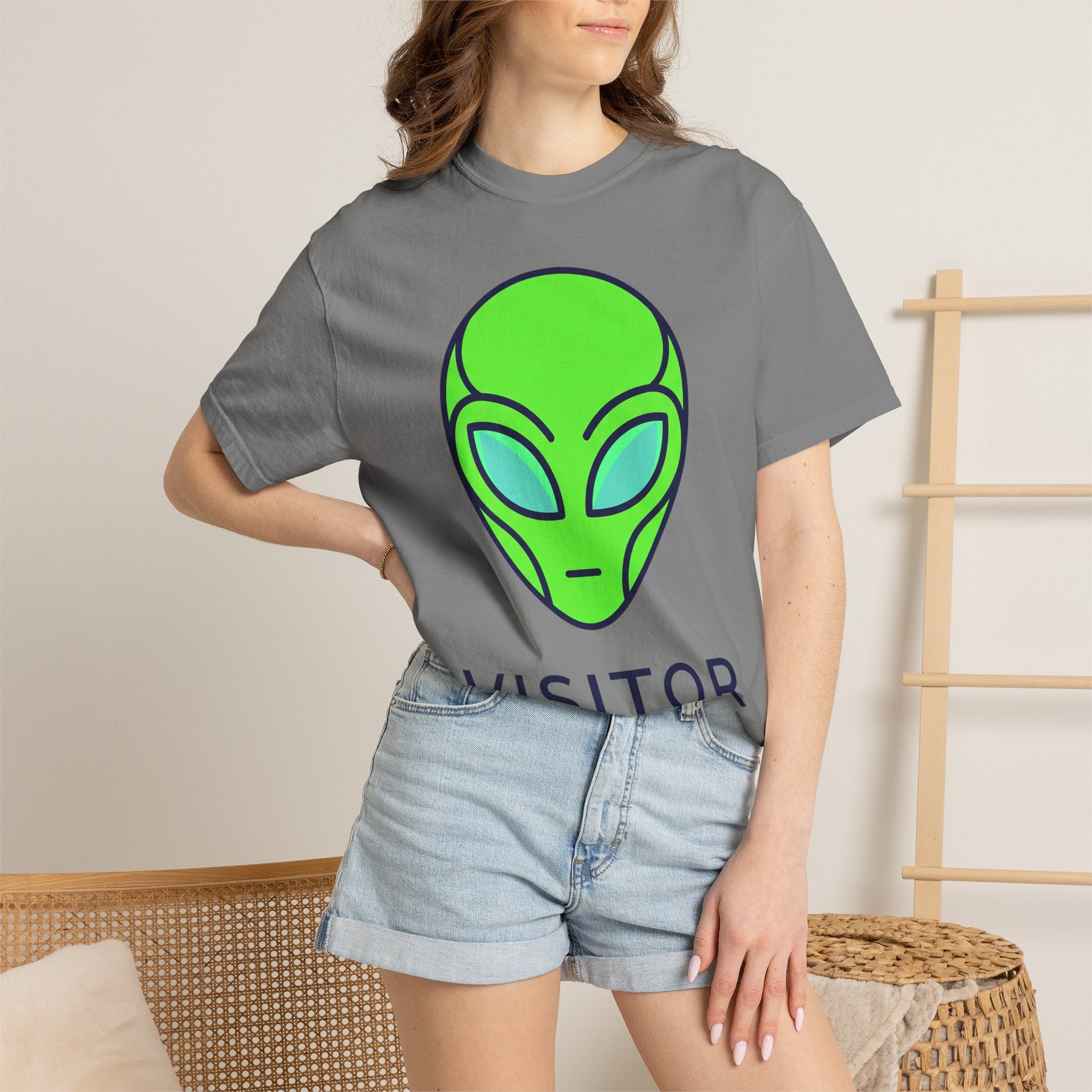 Alien face graphic T-shirt in dark gray with neon green and blue print, worn