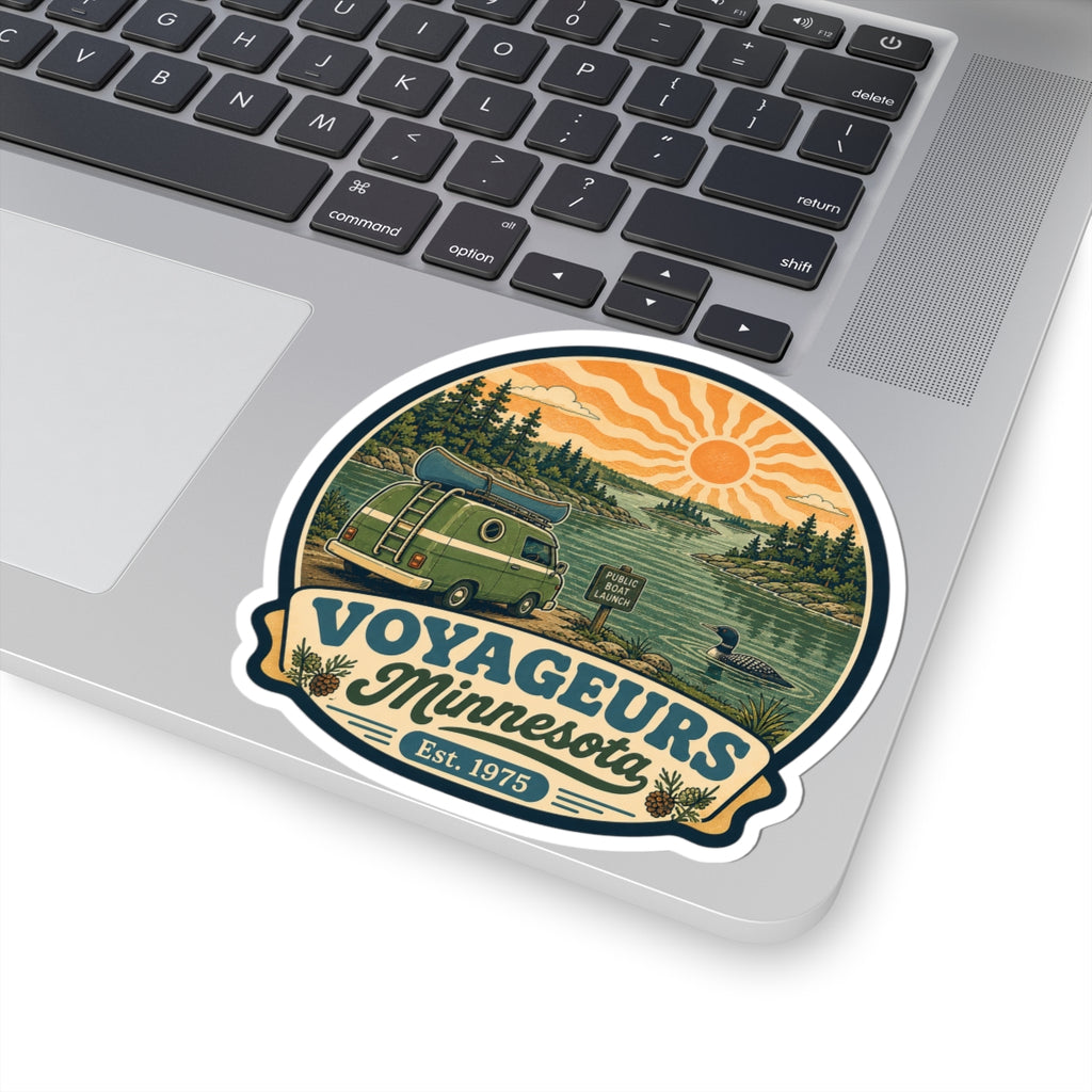 Round vinyl sticker design with green van, pine forest hills, orange sunset rays and “Voyageurs Minnesota”