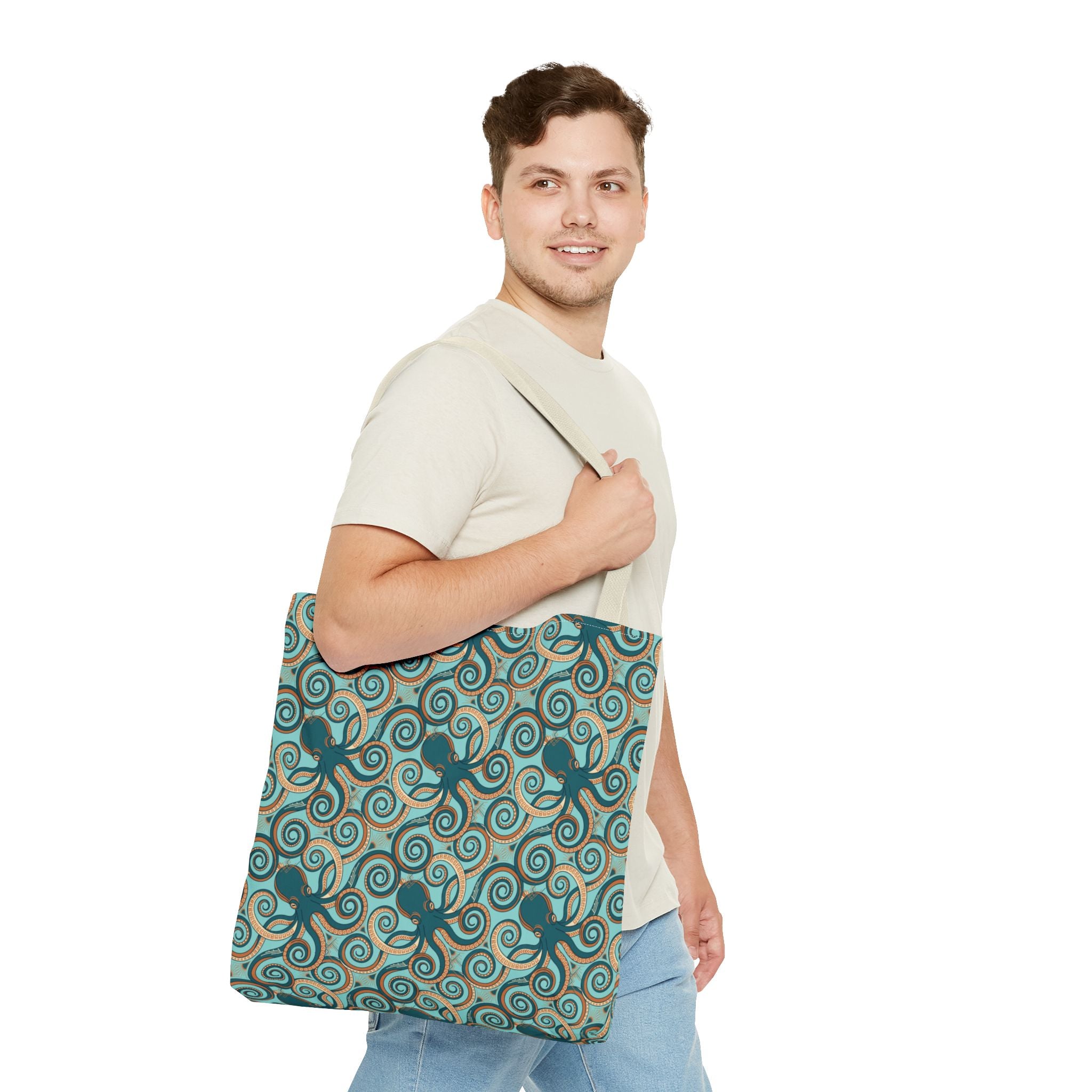 Teal octopus swirl tote bag with rope handles, front view on person.