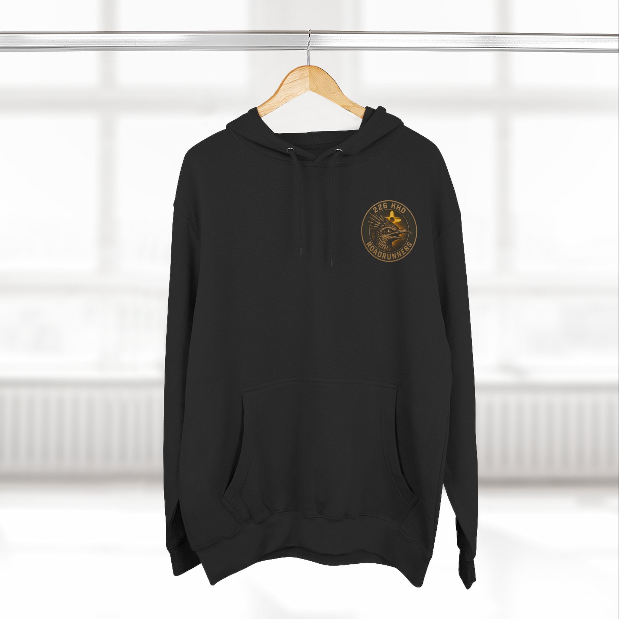 Black pullover hoodie with kangaroo pocket, hood, and small chest emblem.