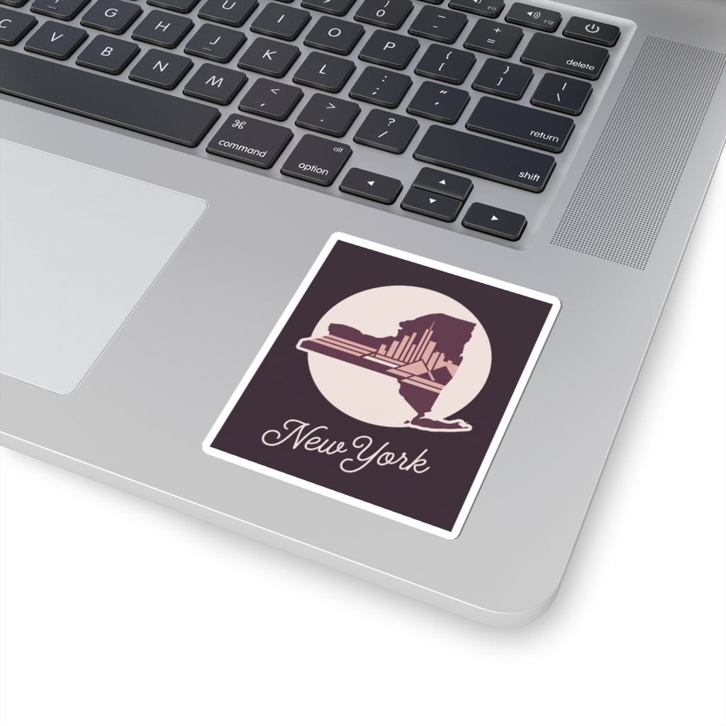 New York skyline decal sticker on a laptop lid, showing circular state silhouette and cursive “New York”.