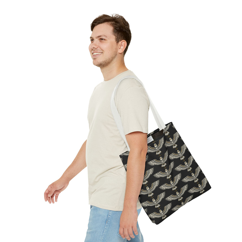 Winged scarab tote bag with repeating gold motifs on black, long light handles