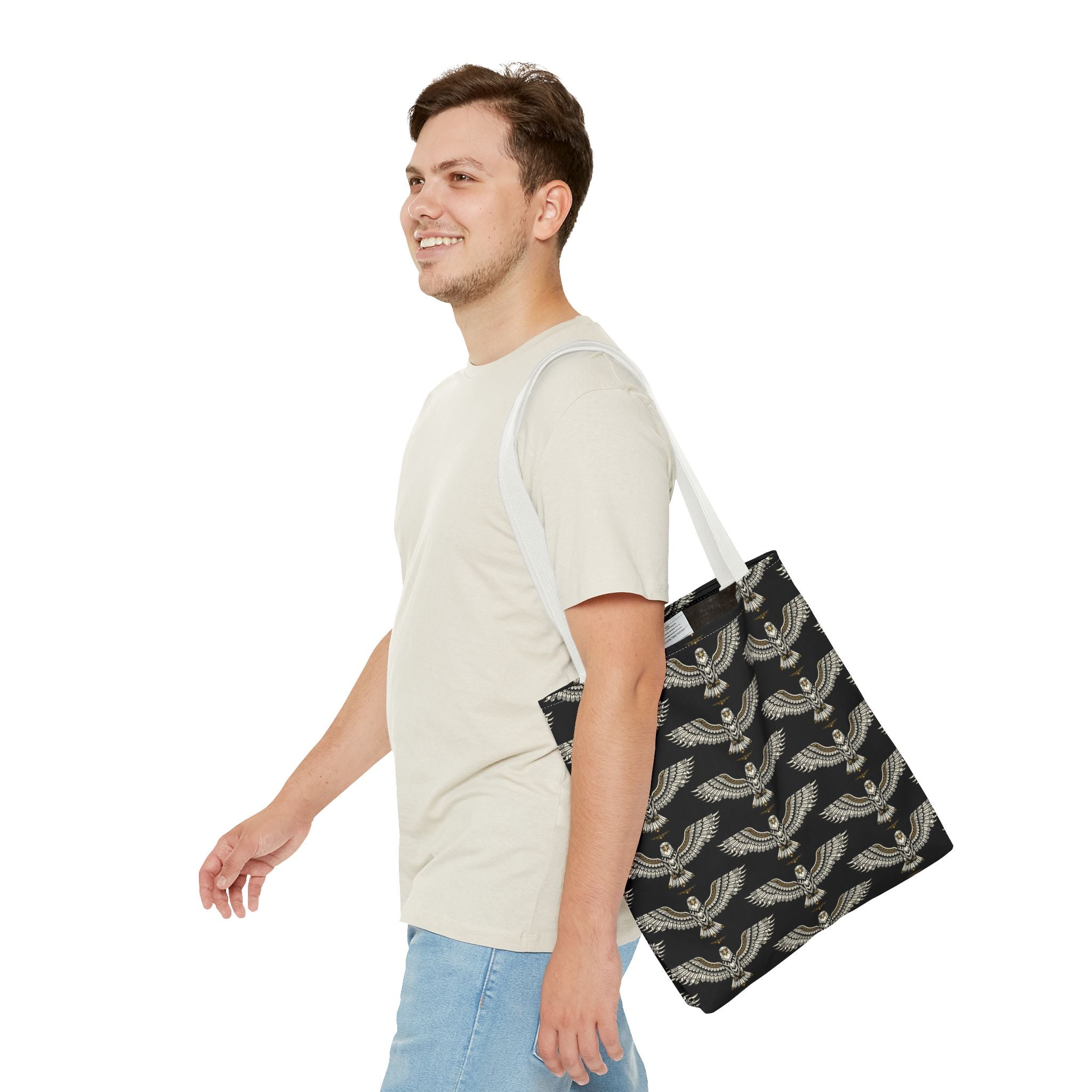 Winged scarab tote bag with repeating gold motifs on black, long light handles