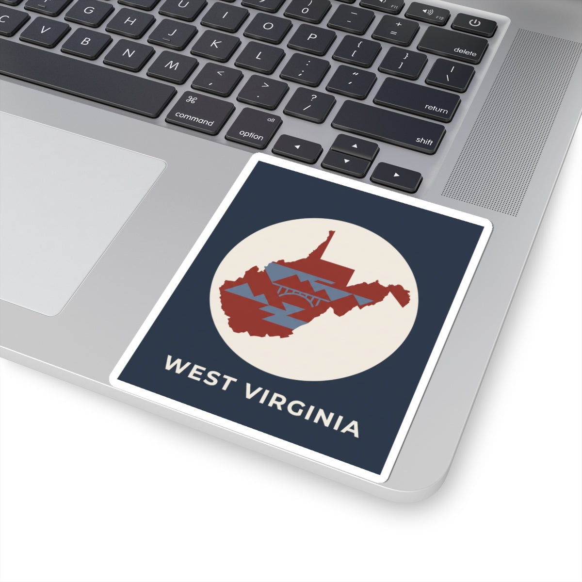 West Virginia map sticker on laptop, navy square with red state silhouette and 'WEST VIRGINIA'