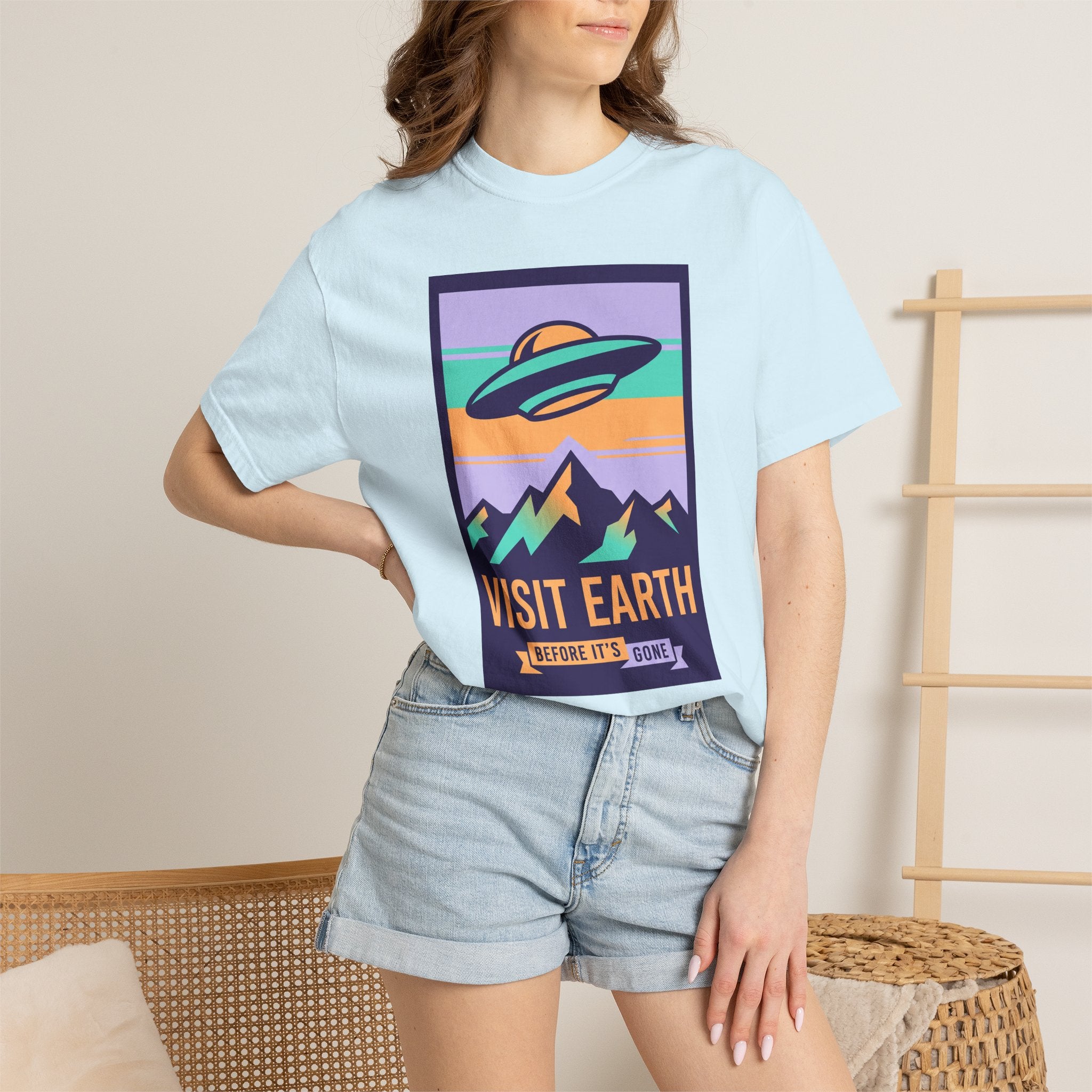 Light blue crewneck T-shirt with retro UFO and “VISIT EARTH” graphic on chest