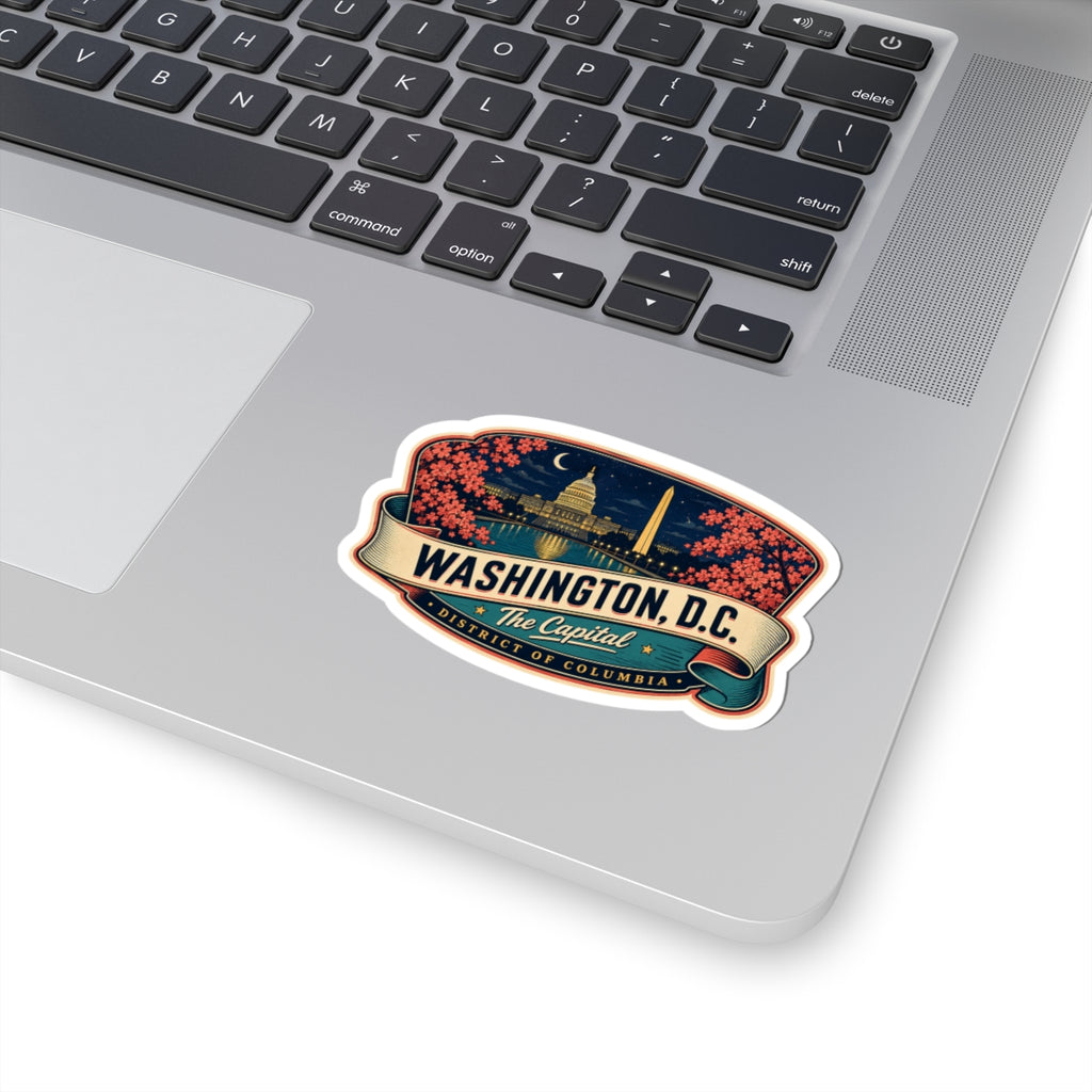 Luggage tag sticker on a laptop showing Washington D.C. landmarks, pink blossoms, and The Capitol