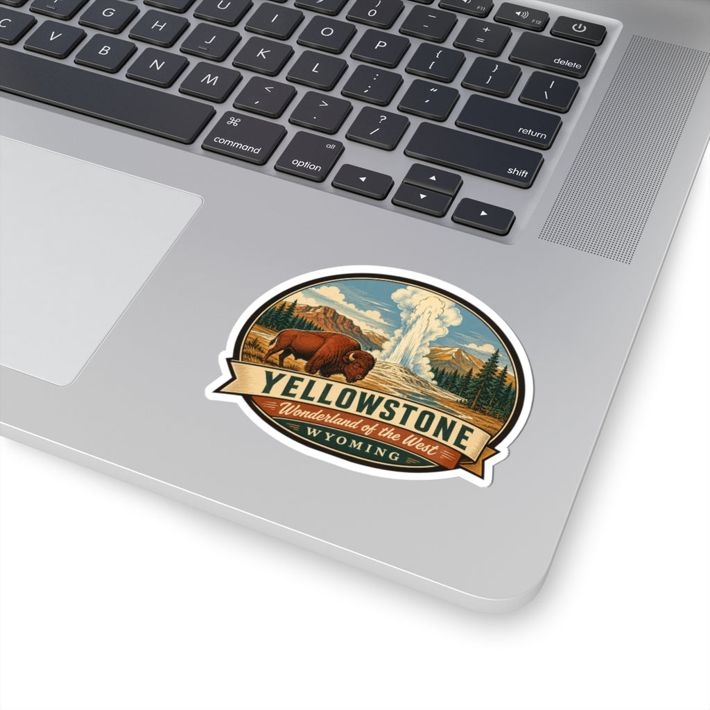 Yellowstone travel sticker on a laptop keyboard; bison, geyser, and Wyoming banner
