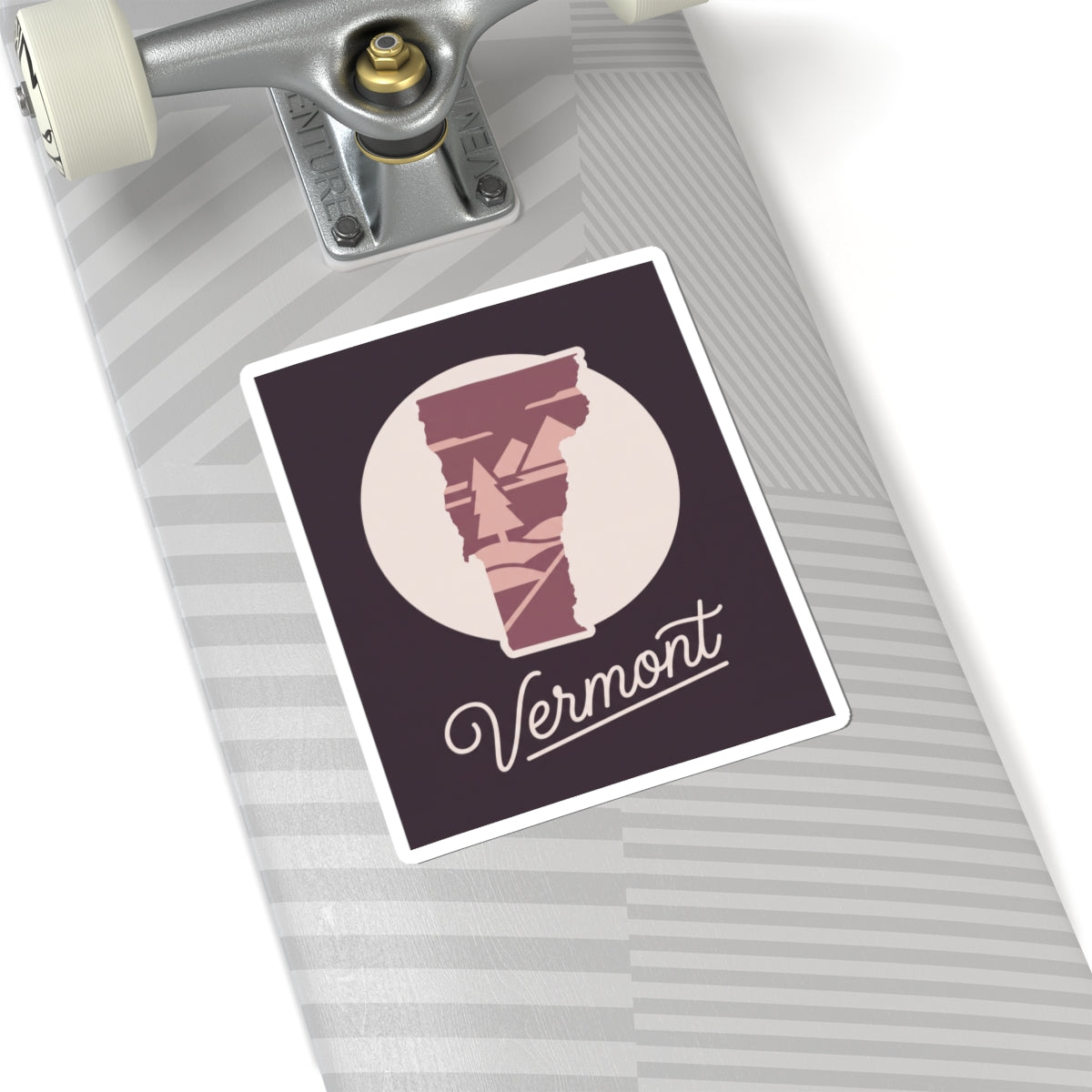 Vermont state silhouette sticker with maroon pine artwork and cursive 'Vermont' on light surface