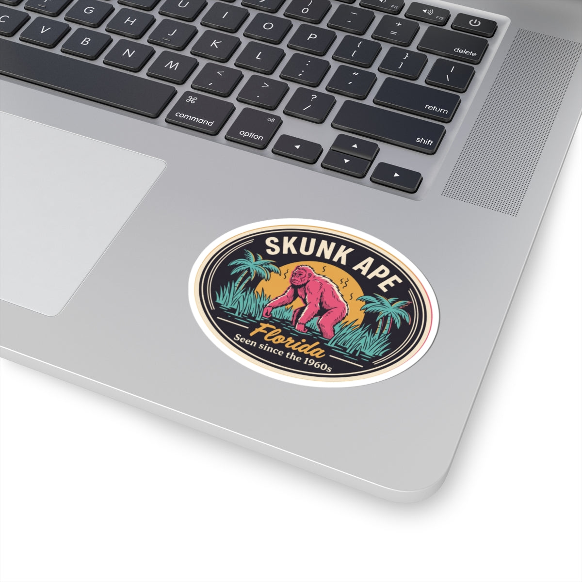 Skunk Ape Florida round sticker showing pink creature, palm trees, “Florida” script, and date slogan