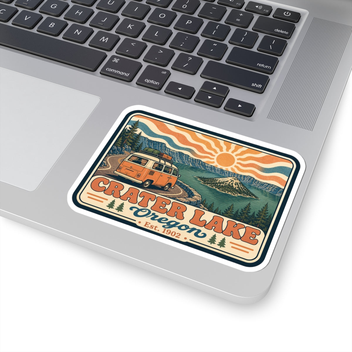 Kiss-cut sticker on laptop, retro Crater Lake Oregon camper van with mountain lake scene