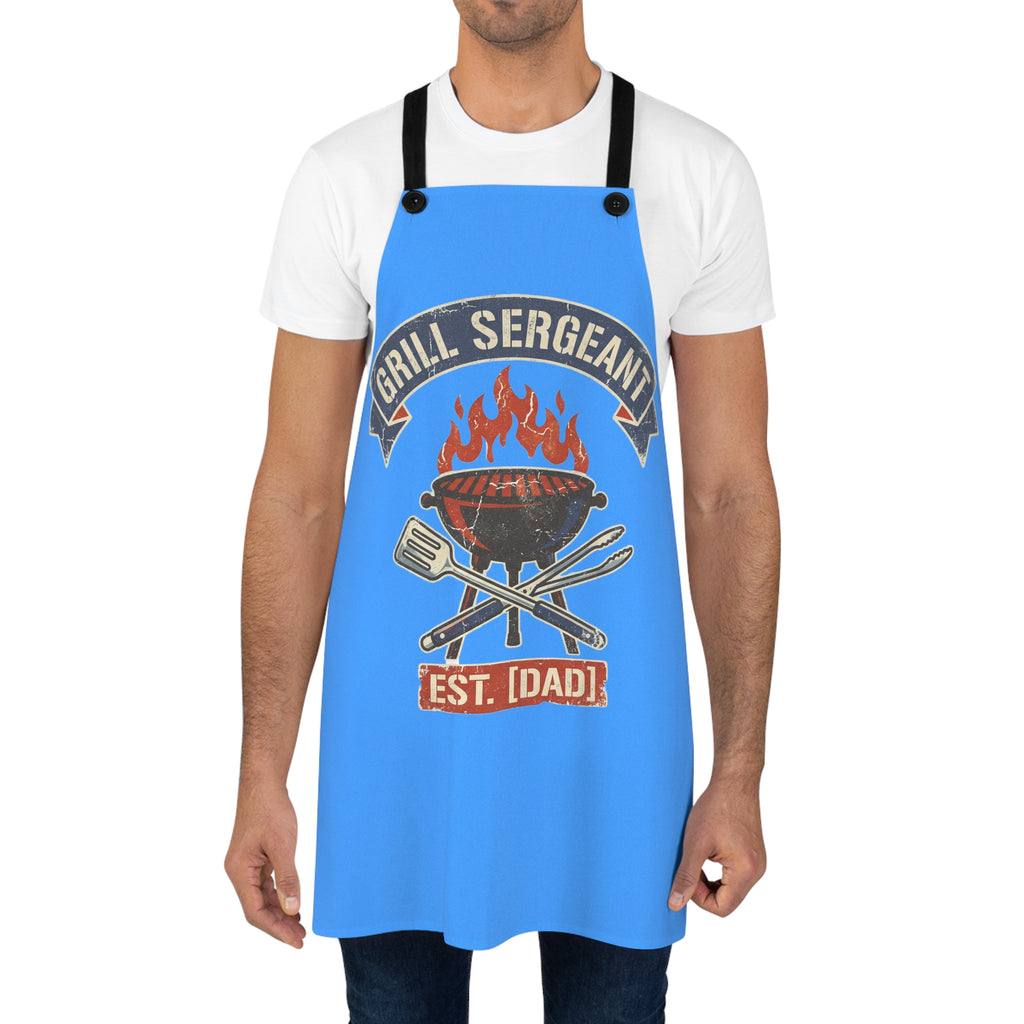 Blue grilling apron worn by man over white T-shirt with flame badge center