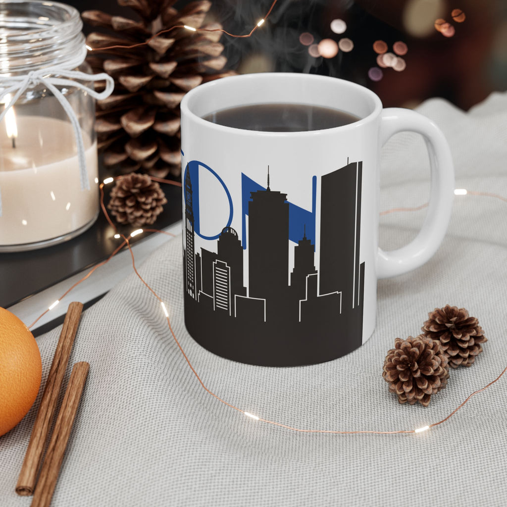 White ceramic mug with blue skyline lettering and black city skyline silhouette