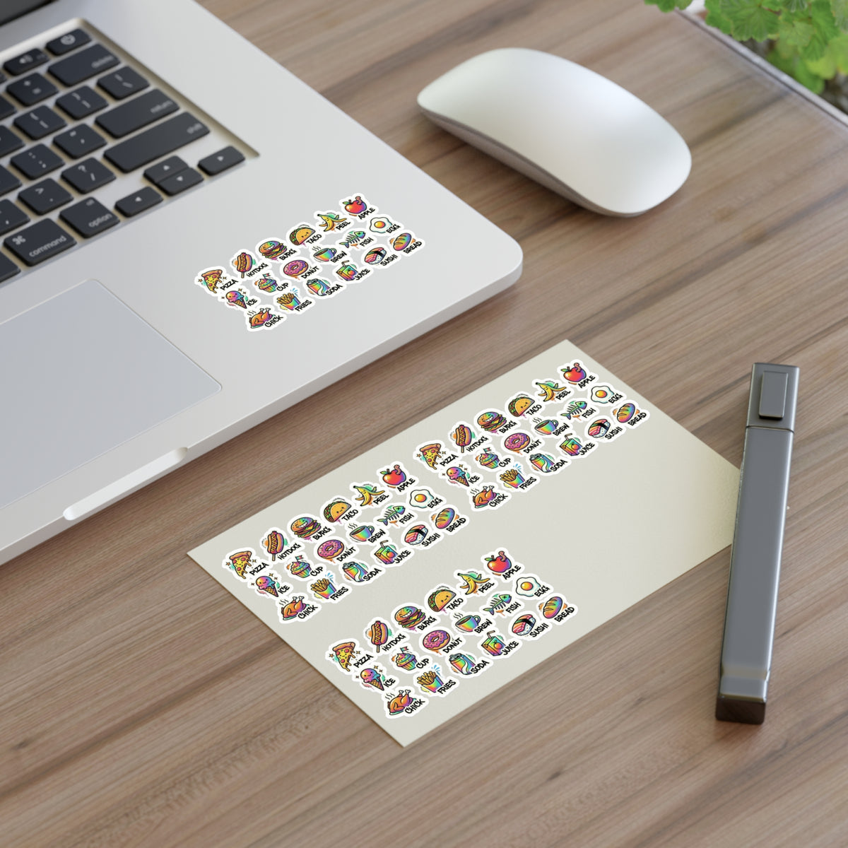 Food icon stickers arranged on a planner sheet on a desk near a laptop