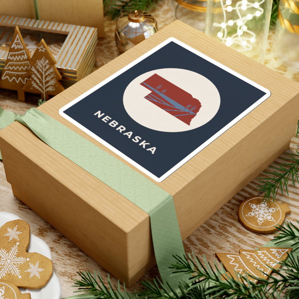 Nebraska sticker with navy square, red state silhouette in white circle, and “NEBRASKA”