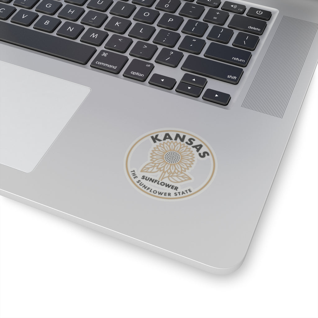 Round Kansas sunflower state vinyl sticker on laptop lid, beige and gray logo